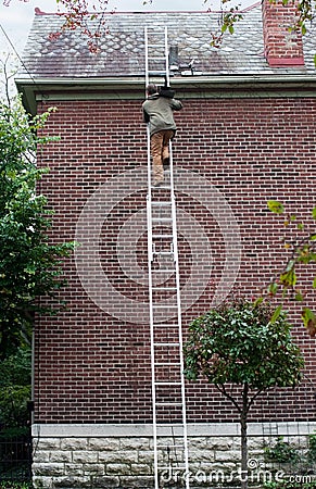 Man Carrying Slate up Ladder Stock Photo