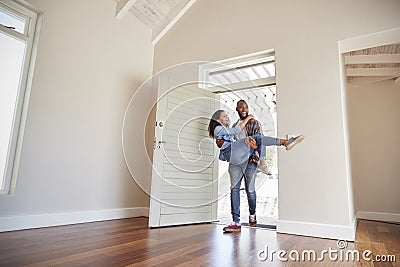 Man Carrying Woman Over Threshold Of Doorway In New Home Stock Photo