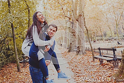 Man carrying woman piggyback, dating, young couple laughing Stock Photo