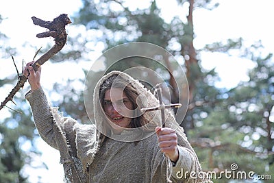 A man in a cassock spends a ritual in a dark forest Stock Photo