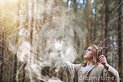 A man in a cassock spends a ritual in a dark forest Stock Photo