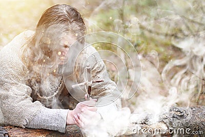 A man in a cassock spends a ritual in a dark forest Stock Photo