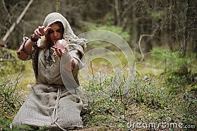 A man in a cassock spends a ritual in a dark forest Stock Photo