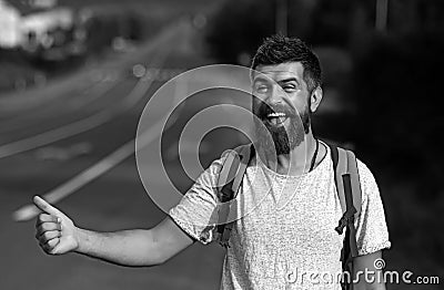 Man catches car on road, auto stop traveling. Auto stop travel. Guy is hitchhiking. A man are voting on the road. Man Stock Photo