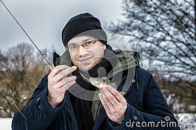 The man caught the first fish on ice fishing Stock Photo