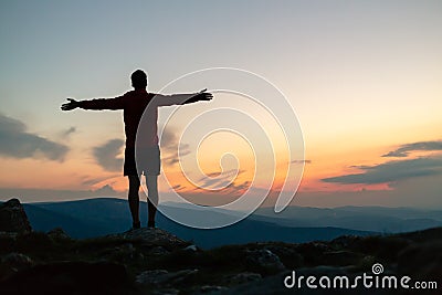 Man celebrating sunset looking at view in mountains Stock Photo