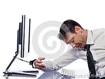 Man chained to computer with handcuffs sad Stock Photo