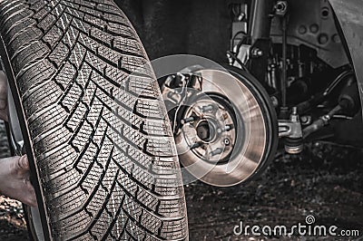 Man is changing summer car wheel, tire before winter Stock Photo