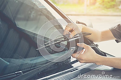 Man is changing windscreen wipers on a car Stock Photo