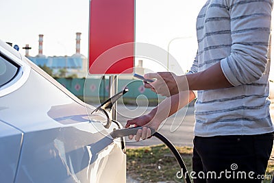 Man Charges electric car Stock Photo