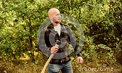 Man checkered shirt use axe. brutal and attractive male in forest. power and strength. lumberjack carry ax. bald Stock Photo