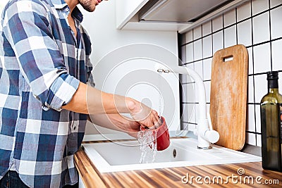 Man in checkered shirt washing dishes on the kitchen Stock Photo