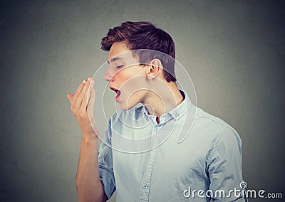 Man checking his breath with hand. Stock Photo