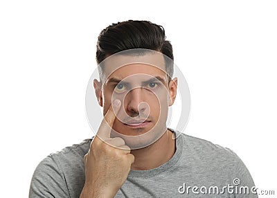 Man checking his health condition on white background. Yellow eyes as symptom of problems with liver Stock Photo