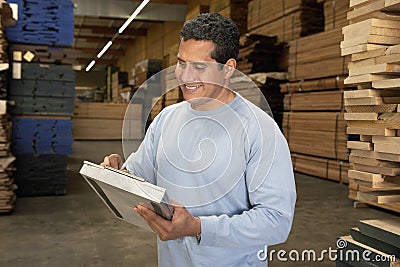 Man Checking Lumber In Warehouse Stock Photo