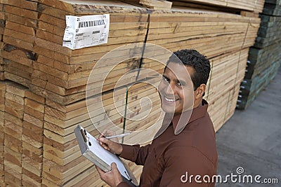 Man Checking Lumber In Warehouse Stock Photo