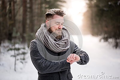 Man checking time in winter woods Stock Photo