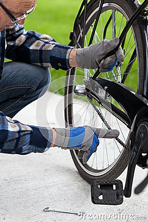 The man checks the chain from the bicycle Stock Photo