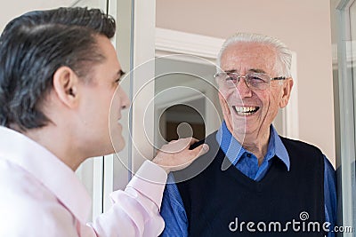 Man Checking On Elderly Male Neighbor Stock Photo