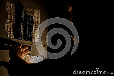 Man Checks Home Fuse Box in a Dark Power Outage Stock Photo