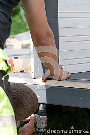 A man checks to see if the wall is level with the floor when installing a gazebo. Stock Photo