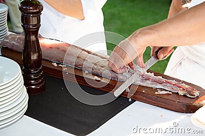 Man chef cuts the salmon on the table Stock Photo