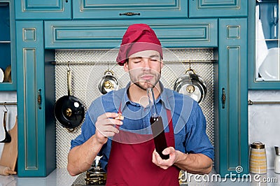 Man chef smell wive vinegar. Red Wine Vinegar benefits. perfect quality. strong aroma. intensity of flavor. enjoy using Stock Photo