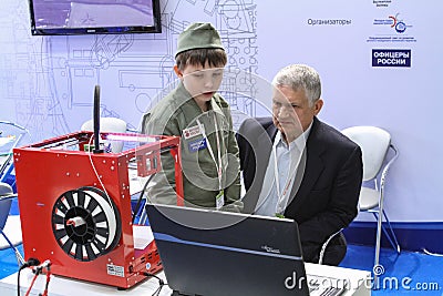 A man and a child are studying a program for working on a 3D printer Editorial Stock Photo
