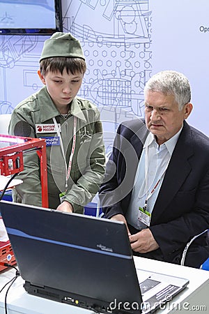A man and a child are studying a program for working on a 3D printer Editorial Stock Photo
