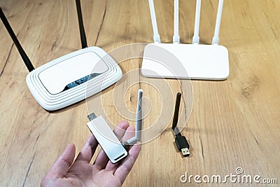 Man choose of different types of Wi-Fi routers, modern and old technology. Wireless ethernet connection signal. USB Wifi Receiver Stock Photo