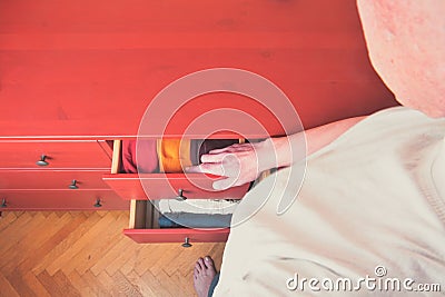 Man choosing orderly folded socks in drawer. Man tiding the clothes. Preparing the clothes. The order in chest of Stock Photo