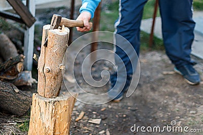 Man chopping wood in the backyard. Lumberjack cuts logs Stock Photo