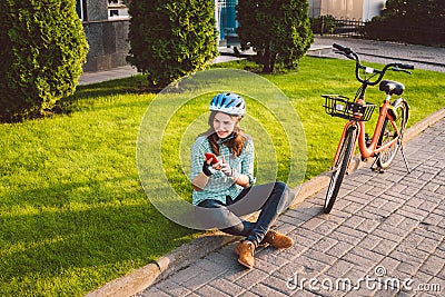 Man and city rolling bicycle, environmentally friendly transport. Beautiful young caucasian woman worker sitting resting on the gr Stock Photo