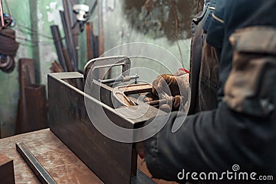 Man clamps iron products into c-clamps. Man works with clamps. Steel workshop concept Stock Photo