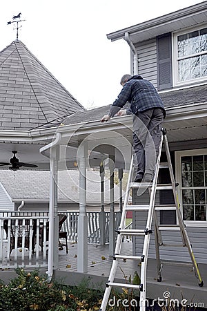 Man cleaning Eaves troughs Stock Photo