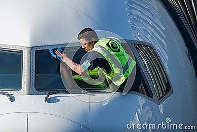 Man cleaning jet plane windows Editorial Stock Photo