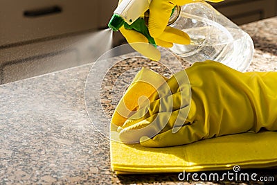 Man cleaning kitchen counter with solution to kill viruses and bacteria Stock Photo