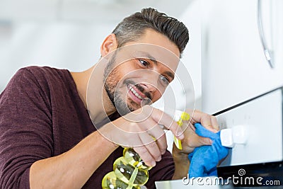 man cleaning oven knob Stock Photo