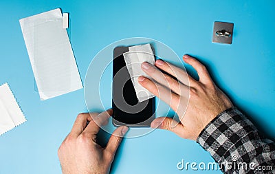 Man cleaning phone screen to apply protective glass Stock Photo