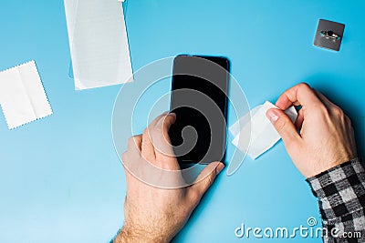 Man cleaning phone screen to apply protective glass Stock Photo