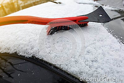 Man cleaning snow from car with brush Stock Photo