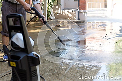 Man cleaning stone with high pressure water jet Stock Photo