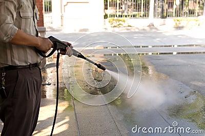 Man cleaning stone with high pressure water jet Stock Photo