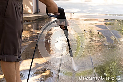 Man cleaning stone with high pressure water jet Stock Photo