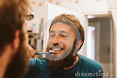 Man cleaning teeth in bathroom Stock Photo