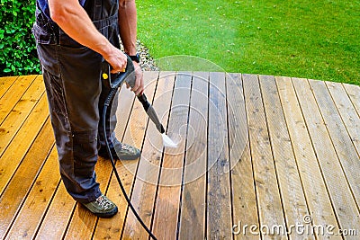 Man cleaning terrace with a power washer - high water pressure c Stock Photo