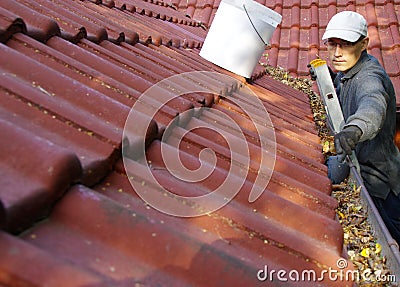 The man cleans the gutters on the roof Editorial Stock Photo