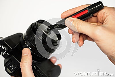 A man cleans a SLR camera with a brush Stock Photo