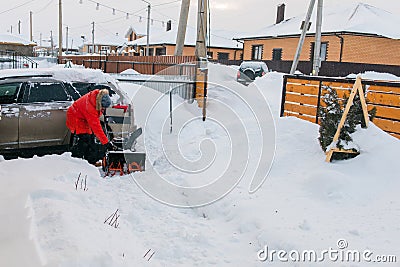 A man clear snow from backyard with snow blower. Winter season and snow blower equipment Stock Photo