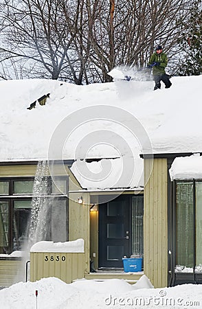 Clearing Snow from a Roof in Quebec Editorial Stock Photo